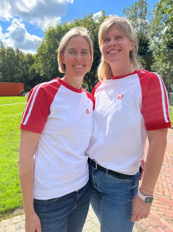 Zwei weibliche Models mit T-Shirt in weiß mit roten mit weißen Strichen Ärmeln, rotes Finanz Informatik Logo auf der linken Brust