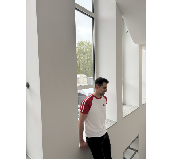 Männliches Model mit T-Shirt in weiß mit roten mit weißen Strichen Ärmeln, rotes Finanz Informatik Logo auf der linken Brust